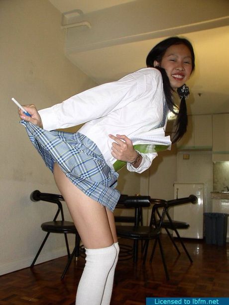 Asian schoolgirl with pigtails strips and shows her shaved pussy up close