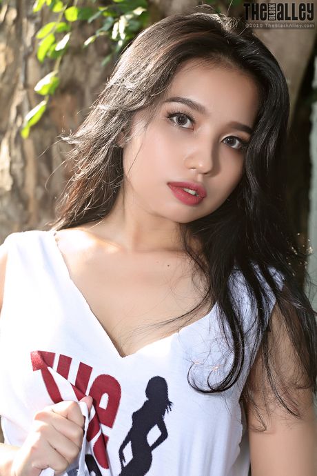 Asian teen Norah strips and shows her hairy pussy in a solo outdoors