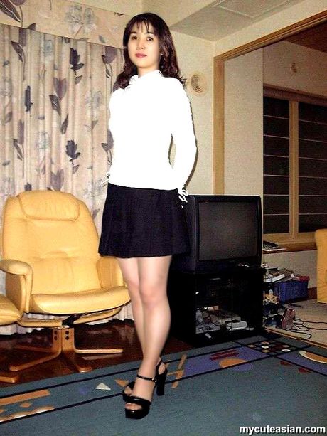 Amateur Asian girl with a big booty strips and toys her pussy on a bed