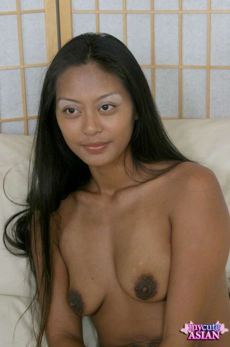 Amateur Asian girl with tiny tits strips and rubs her twat on the bed